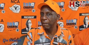 Lovemore Madhuku speaking at an NCA press conference in Zimbabwe with “Take Charge” campaign branding.